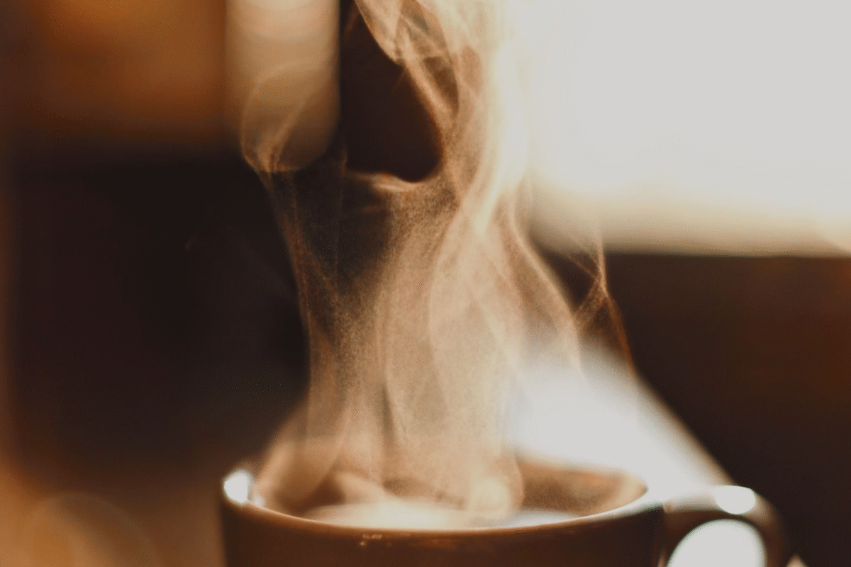 A steaming cup of coffee on a cozy table – symbolizing the start of a focused, energized morning wellness routine.