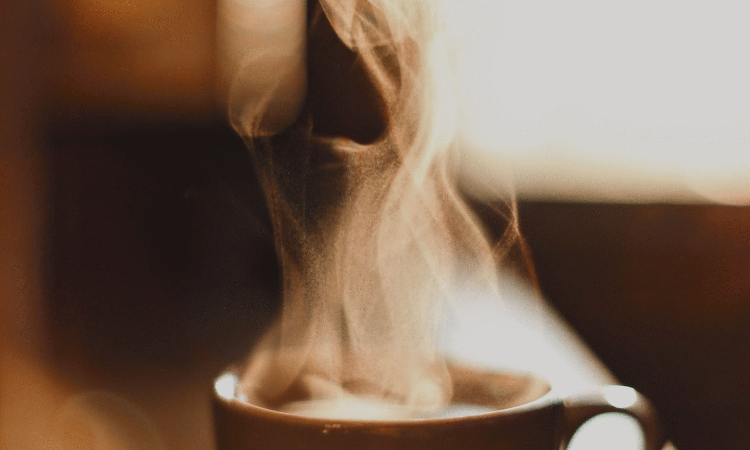 A steaming cup of coffee on a cozy table – symbolizing the start of a focused, energized morning wellness routine.
