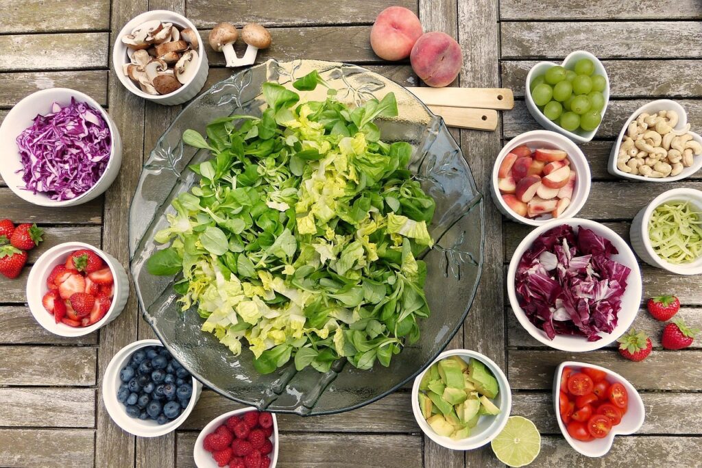 Fresh salad with fruits, berries, and vegetables, showcasing healthy eating and plant-based nutrition.
