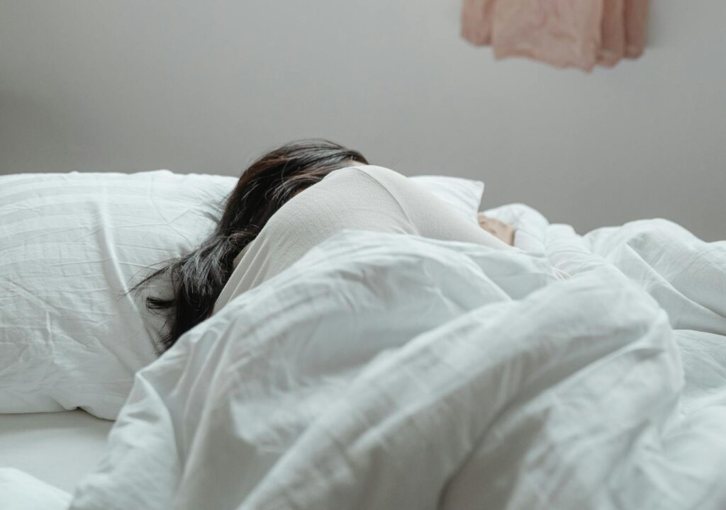 Woman resting peacefully near alarm clock, showing importance of deep sleep secrets for better mornings.