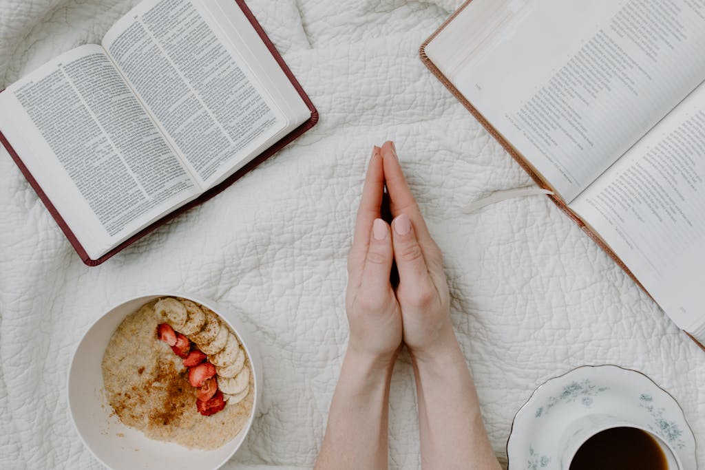 Gentle self-care reflection moment with a person praying, an open Bible, oatmeal, and coffee representing emotional healing and inner calm.