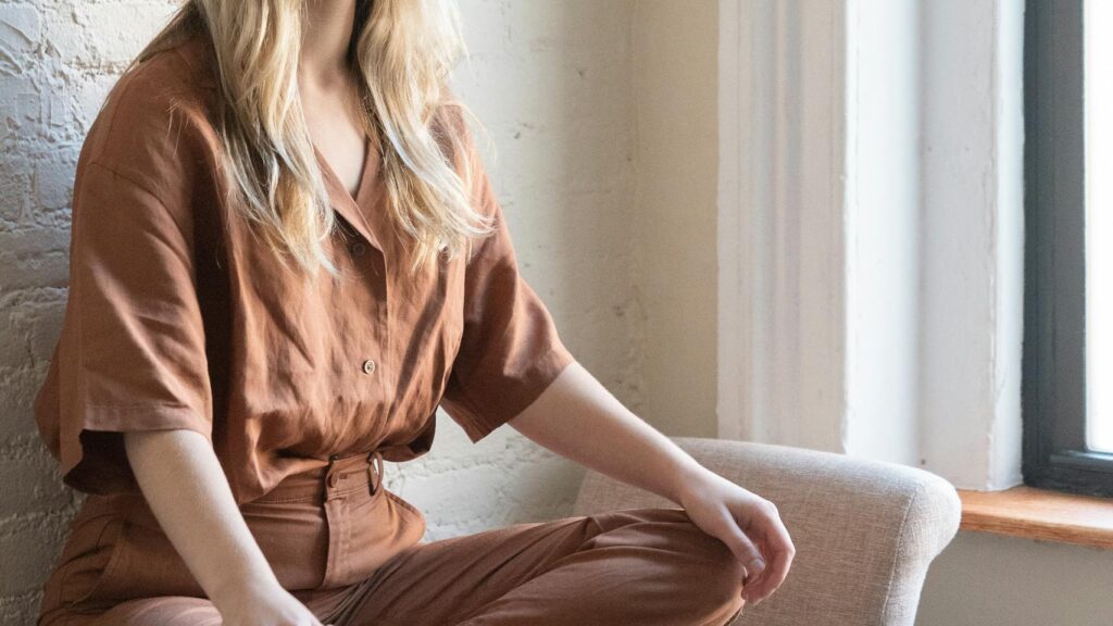 A women meditating indoors and practicing breathing exercises with serene expressions reflecting on practical self-care and holistic healing.